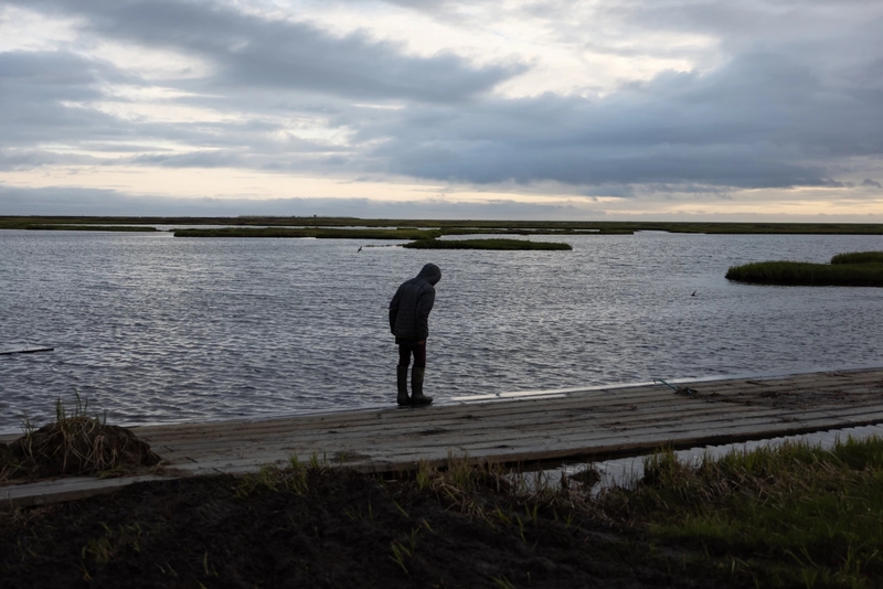Seth Friend, 12, stands near a pond in Kwigillingok last month. (Katie Baldwin Basile for Anchorage Press)