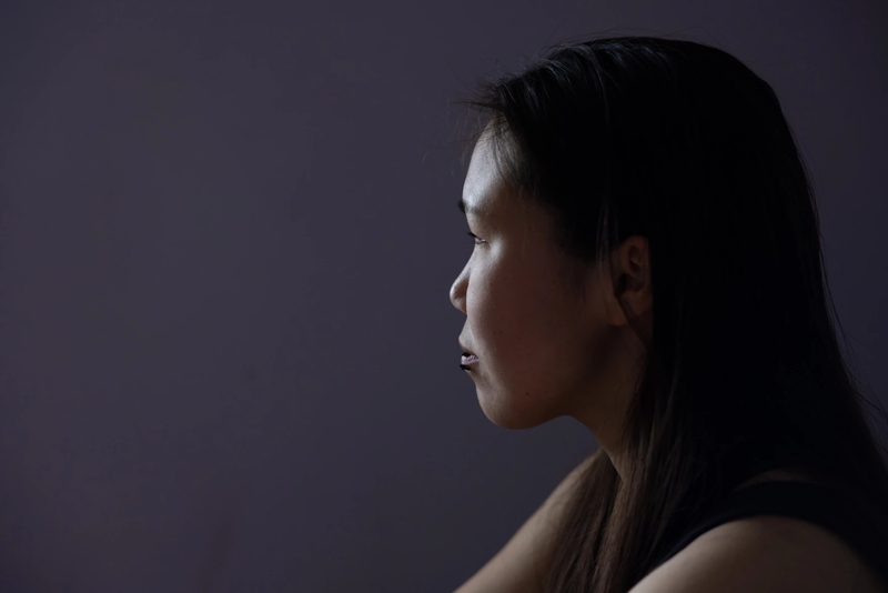 Ariel Friend, 20, sits on her bed last month in a room she shares with her aunt in Bethel. Friend relocated from Kwigillingok after ex-typhoon Halong struck the village. (Katie Baldwin Basile for Anchorage Press)