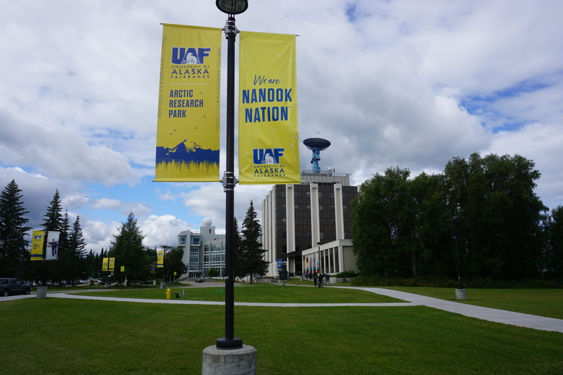 A sign, seen July 24, 2026, celebrates the University of Alaska Fairbanks' status as a leader in Arctic research. Behind the sign are buildings that house UAF's Geophysical Insititute and International Arctic Research Center. (Photo by Yereth Rosen/Alaska Beacon)