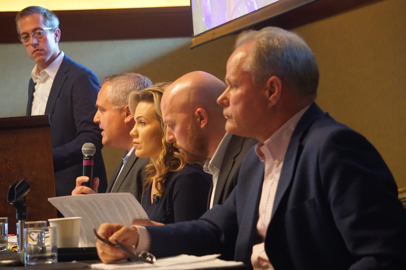 Former Attorney General Treg Talor speaks at a gubernatorial candidate forum on Sept. 16, 2026, while Anchorage business owner and talk-show host Bernadette Wilson, former state Rep. Jonathan Kreiss-Tomkins and former Anchorage Mayor Dave Bronson listen. At the lecturn is Jared Kosin, president of the Alaska Hospital and Healthcare Association. The organization held the forum in Girdwood, and the event was focused on healthcare issues. (Photo by Yereth Rosen/Alaska Beacon)