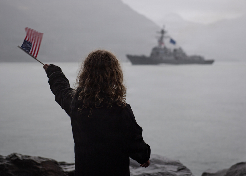 A Whittier resident waves an American flag to welcome the USS Ted Stevens, to town on Sept. 27, 2026. The ship is the Navy’s newest Flight III Arleigh Burke-class guided-missile destroyer. (U.S. Navy Photo by Mass Communication Specialist 1st Class Chelsea D. Daily/U.S. Navy)