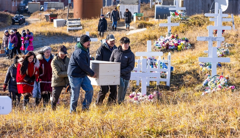 The casket of Tummassak is carried up a hill to be reburied at the Lutheran cemetery in Shishmaref, Alaska, on Oct. 4, 2026. Tummassk was an Alaska Native student who died more than 100 years ago while attending the Carlisle Indian Industrial School. Her remains finally were returned home to Alaska in October (Credit: Charles Fox/Special to ICT)