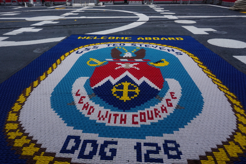 A welcome mat on USS Ted Stevens, seen on Oct. 1, 2026, when the new warship was docked on Whittier, features the motto "Lead With Courage." (Photo by Yereth Rosen/Alaska Beacon)