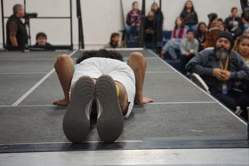 Quentin Odomin, a Native Youth Olympic athlete, demonstrates the traditional seal hop at the Oct. 12, 2026, Indigenous Peoples Day celebration at Alaska Pacific University. (Photo by Yereth Rosen/Alaska Beacon)
