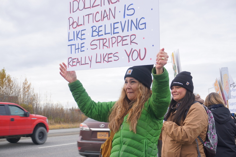 Gretchen Manning-Hopping is among the protestors lining the Parks Highway in Wasilla on Oct. 13, 2026, in the afternoon of a campaign rally by President Donald Trump in the city. Trump was in Wasilla to stump for U.S. Sen. Dan Sullivan, R-Alaska. (Photo by Yereth Rosen/Alaska Beacon)