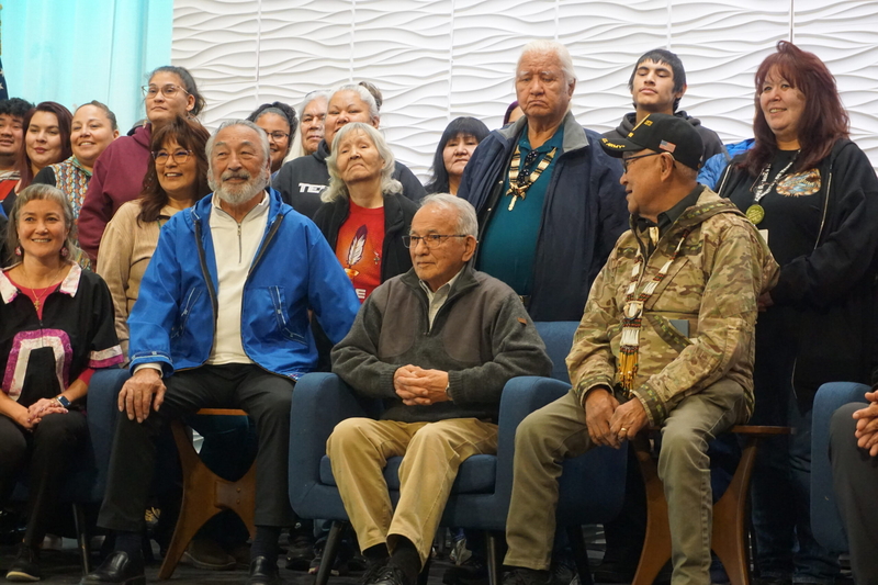 Longtime Native leader Willie Hensley, sesated in the front and wearing a blue parka, poses for photos on Oct. 22, 2026, with several other past and present leaders of the Alaska Federation of Natives. The photos were taken after a panel discussion with Hensley and others at the AFN confention that reflected on the organization's 60-year history. (Photo byYereth Rosen/Alaska Beacon)