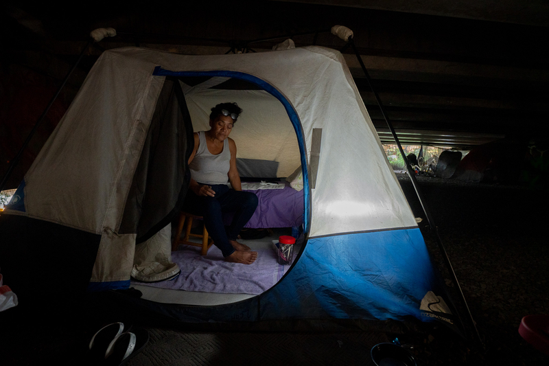 Kim Mathias sits in the tent she erected under a bridge near the Ke'ehi Transfer Station. Mathias, 55, has been at her current location for almost one year. Originally from Hilo, Mathias suffered three strokes and has mild residual weakness and memory problems, she said.
