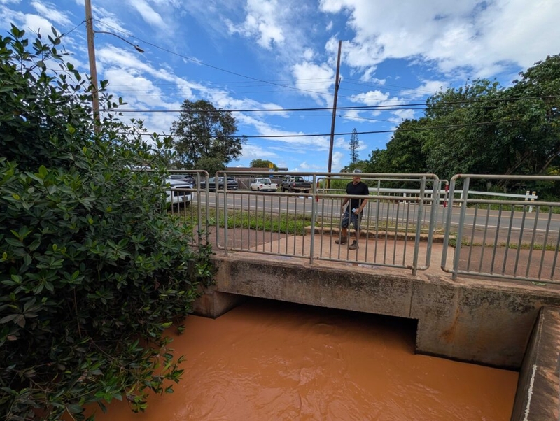 Kanoa Dahlin stands on a culvert many have blamed for being too small, too clogged and too overwhelmed to handle the floodwaters coming from uphill during the March Kona low storms.