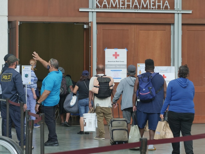 People arrive to shelter at the Hawaii Convention Center in Honolulu, Sunday, July 26, 2020. Oahu began opening up storm shelters around the island early Sunday morning as Hurricane Douglas forecasters warn of damaging wind, heavy rainfall, and dangerously high surf from the category 1 storm.  (Ronen Zilberman photo Civil Beat)
