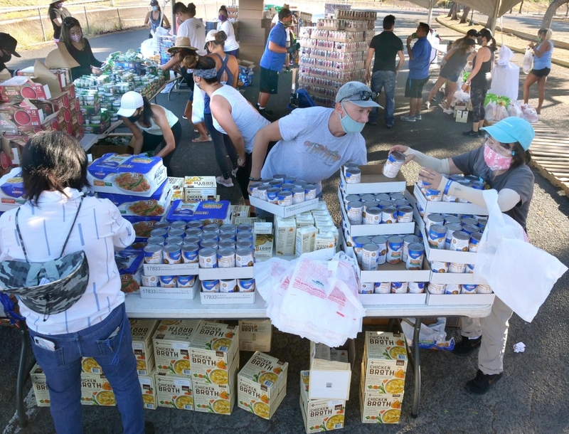Volunteers from the HLTA (Hawaii Lodging &amp; Tourism Assoc.) and Aloha Harvest organize food donations for a drive-thru distribution event, at Aloha Stadium, Friday, August 14, 2020. The event has prepared 1,000 food bundles for hospitality workers and their families. (Ronen Zilberman photo Civil Beat)