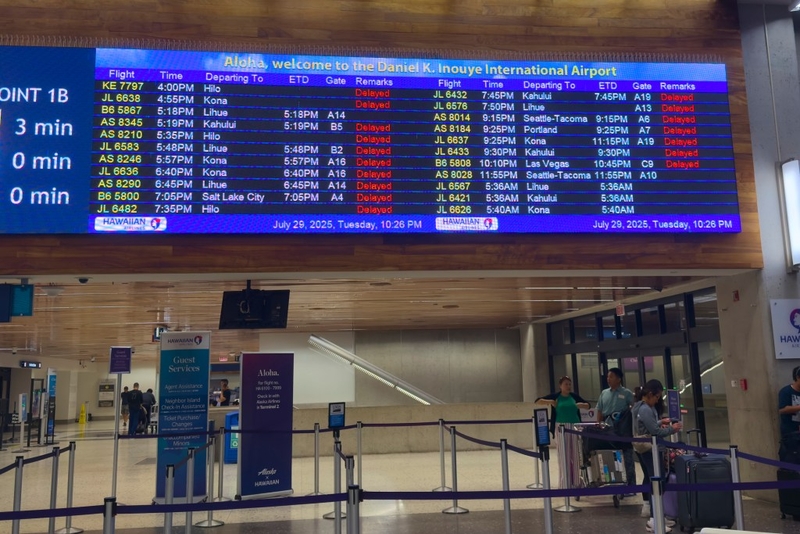 Daniel K Inouye International Airport was the scene of many delays related to the incoming Tsunami on July 29th, 2025.  The travel boards depicted the numerous delays that came about because of the Tsunami.(David Croxford/Civil Beat/2025)