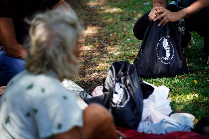 Bags filled with necessities are handed out by Hawaiʻi Health and Harm Reduction Center’s Housing and Outreach Manager Michelle Wilkins and Youth Services Navigator Ashley Rueda to homeless Tuesday, July 21, 2026, at Ala Moana Regional Park in Honolulu. Their program, Guide on the Side, is an outreach program which focuses on at-risk,  homeless youth, especially LGTBQ+ kids. Local homeless service providers are uncertain about if their federal funding will be renewed after the federal government changed