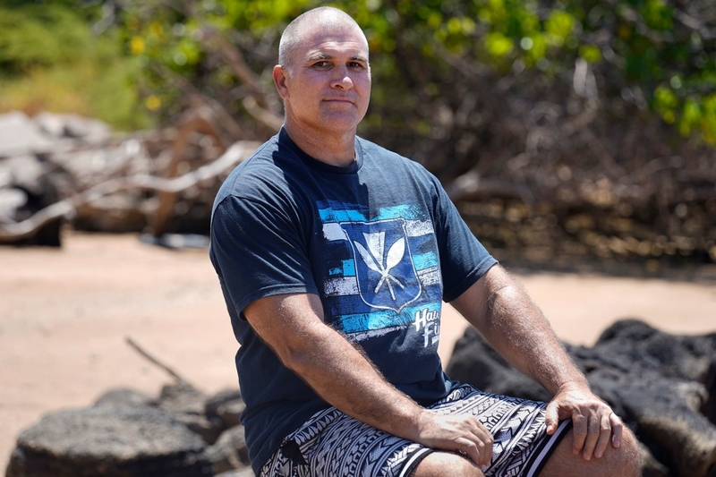 Hawaiiloa Mowat sits on the beach behind his homestead where an endangered Hawaiʻian Monk Seal hauls up to his home Thursday, July 30, 2026, in Kaunakakai, Moloka‘i. The death of RL80 and the recent social-media star RU99, named by local school keiki as Namaka‘ele‘ōlino, or Lino Boy, has gone viral hauling up on a Mowat’s homestead. (Kevin Fujii/Civil Beat/2026)