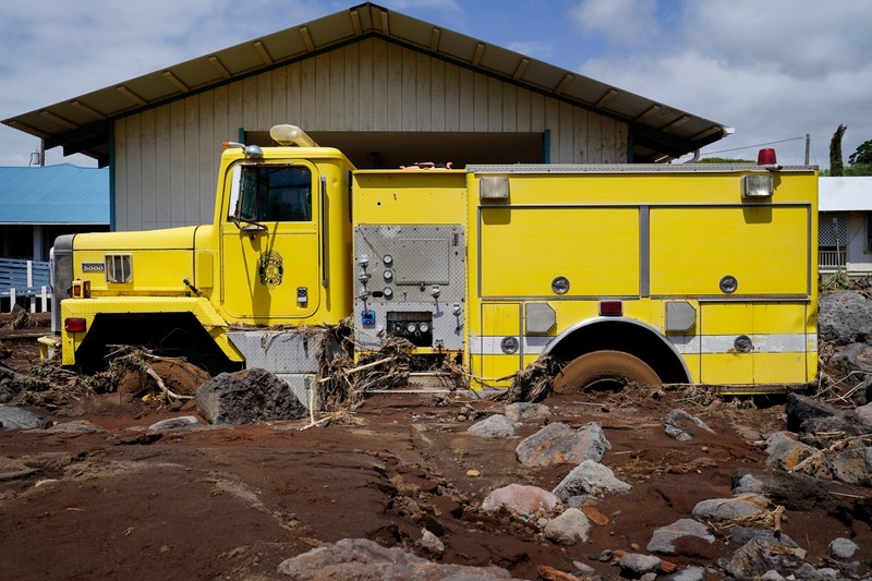 A Hawaiʻi County Fire Department vehicle lies buried in mud and debris as Nāʻālehu continues to recover Tuesday, Aug. 18, 2026, on Hawaiʻi Island. Hurricane Lala made a close pass to the South Point of the Big Island Saturday. (Kevin Fujii/Civil Beat/2026)