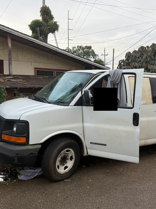 A white van with a gray fabric hanging from its open doors.