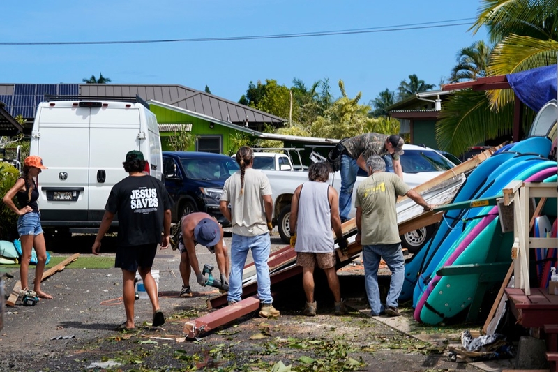 Friends and ʻohana remove a wall that collapsed on a Hanalei Surfboard Rental rack Wednesday, Sept. 9, 2026, in Hanalei. (Kevin Fujii/Civil Beat/2026)
