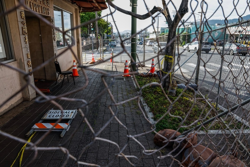Chainlink fencing surrounds the entrance to Happy Days restaurant, Tuesday, Sept. 29, 2026, in Kaimukī. Cleanup efforts by the City and State have begun on the beleaguered restaurant, whose roof collapsed last month.  (Jamm Aquino/Civil Beat/2026)