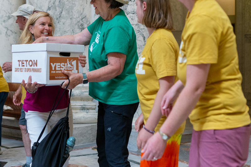 Supporters of the Idaho open primary initiatives lug boxes of signatures in support of the initiative through a line in the Idaho State Capitol Building.