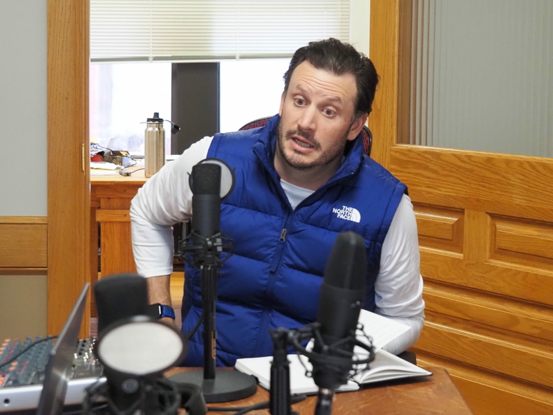 Eric Stafford sits at a microphone for a podcast recording