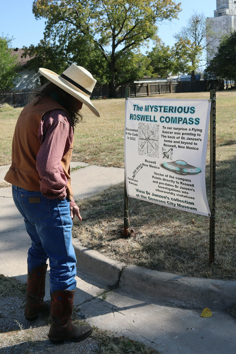 Jim Gray points to the "Roswell Compass" on the curb outside