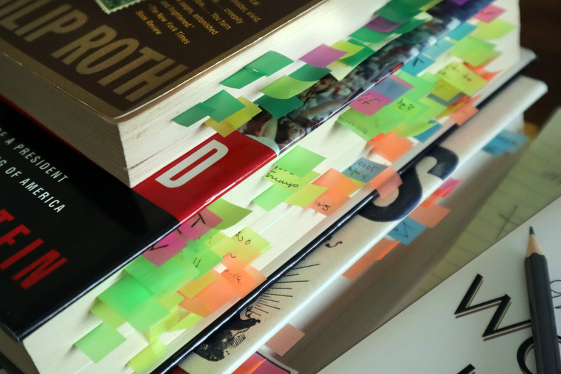 A stack of books with sticky notes