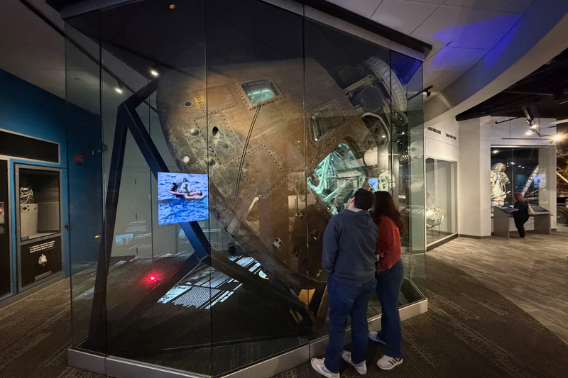Jorge Montiel of Wichita and Deborah Medina of Garden City peer inside Odyssey, the Apollo 13 command module, on April 15, 2026, at the Cosmosphere space museum at Hutchinson, Kansas.