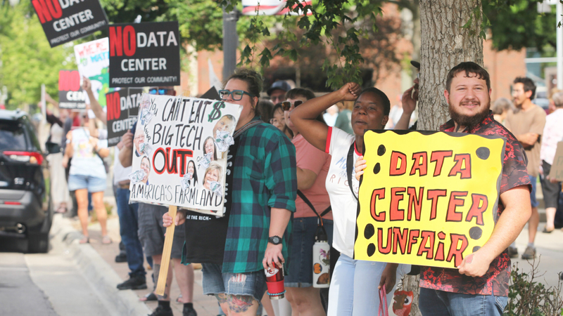 Activists opposed to a data center protest on June 23, 2026, outside the municipal auditorium in Emporia.