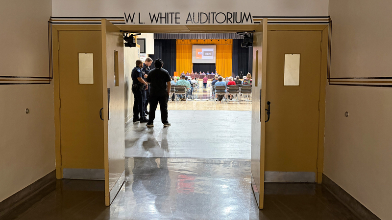 Police officers stand near the doors during a six-hour public comment session on rezoning related to a proposed data center June 23, 2026, at White Auditorium in Emporia. The planning commission tabled a vote on the rezoning to June 30.