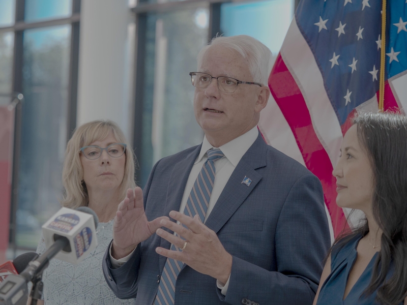 Overland Park Mayor Curt Skoog, center, talks to reporters June 1, 2026, at the Secretary of State's Office in Topeka after filing as candidates for the Democratic primary for governor