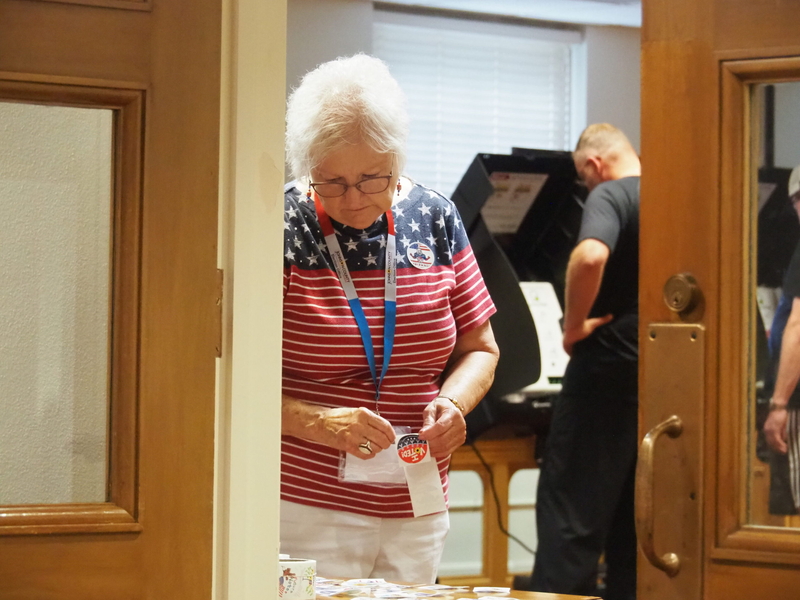 An election worker prepares to hand out "I voted" stickers to Johnson County participants in the Aug. 4 primary election to consider a proposed constitutional amendment and determine nominations by the Democratic and Republican parties