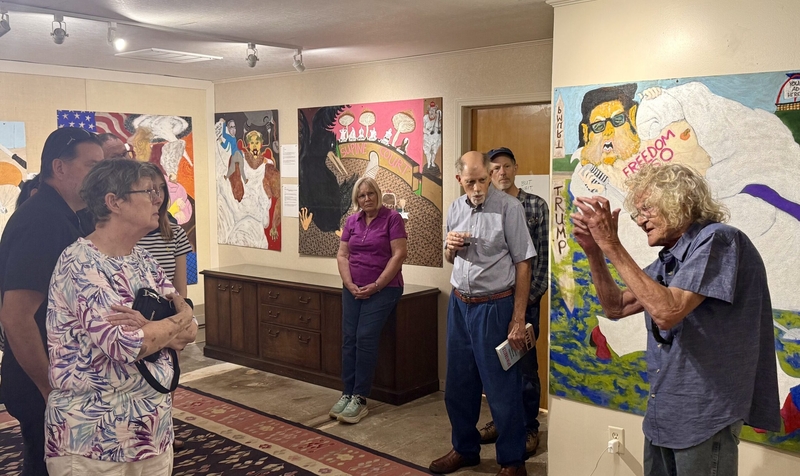 Lindsborg painter Mike Hartung (right) explains his latest exhibit at the Smoky Valley Arts &amp; Folklife Center on Sunday.