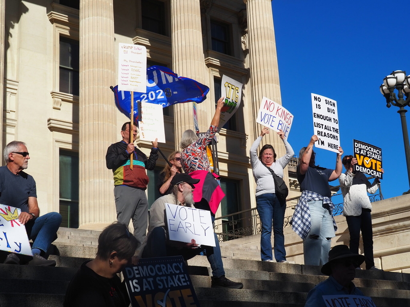A contingent attending a rally Saturday outside the Kansas Capitol in advance of the Nov. 3 election do their best to obscure the lone person waving a flag in support of President Donald Trump.