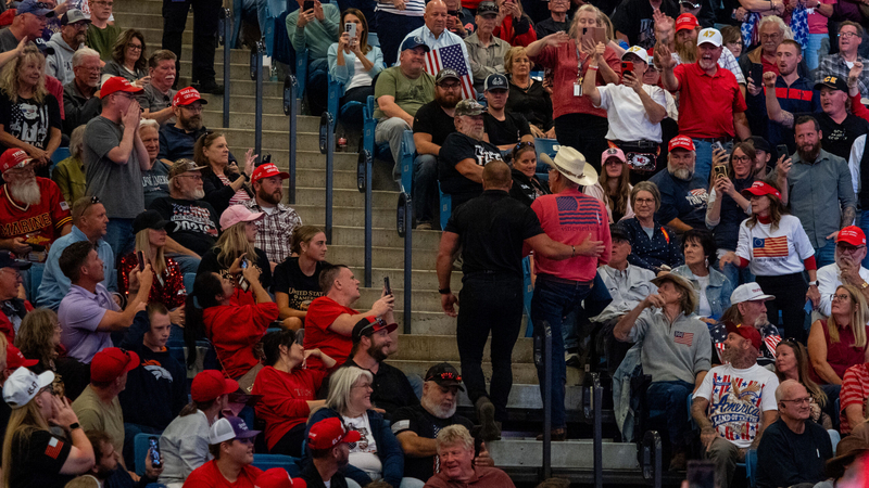 A protester is escorted from President Donald Trump's rally Oct. 19, 2026, in Park City, Kansas.