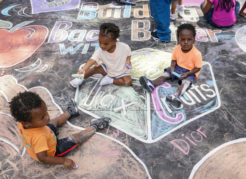 Children from the KU Kids Deanwood Childcare Center complete a mural celebrating the launch of the Child Tax Credit on July 14, 2021, at the KU Kids Deanwood Childcare Center in Washington, D.C.