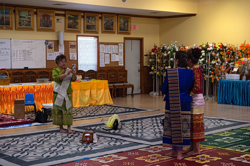 Laotian women take photos inside the Wat Thammarattanaram sermon hall after a religious ceremony.