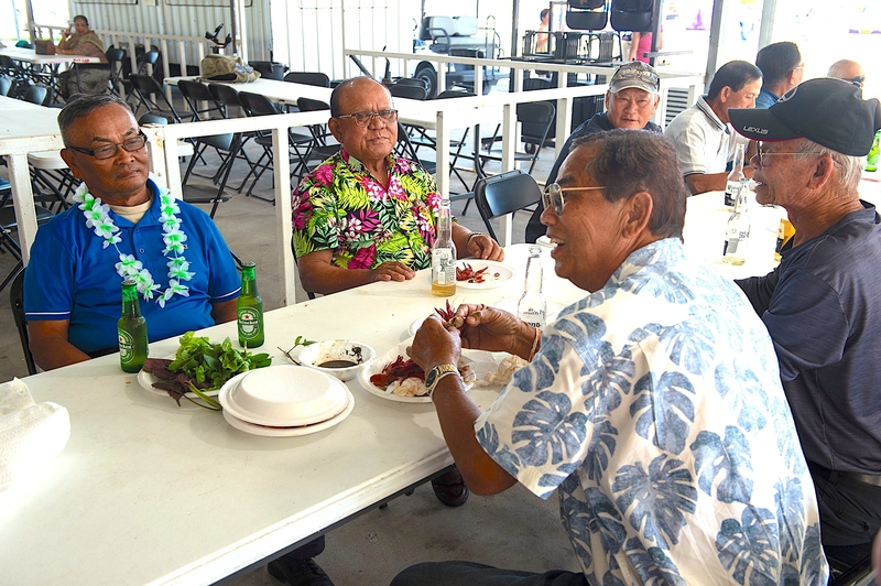 Laotian men eat crawfish served alongside traditional Laotian and Vietnamese dishes