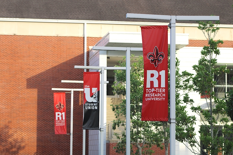Vertical banners hang from lamp posts outside the student union at the University of Louisiana at Lafayette.