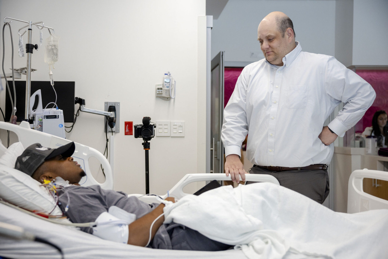 Pediatric hematologist and oncologist Dr. Zach LeBlanc, right, talks to Daniel Cressy, 22, as he undergoes gene therapy for sickle cell disease at Manning Family Children's Hospital in New Orleans