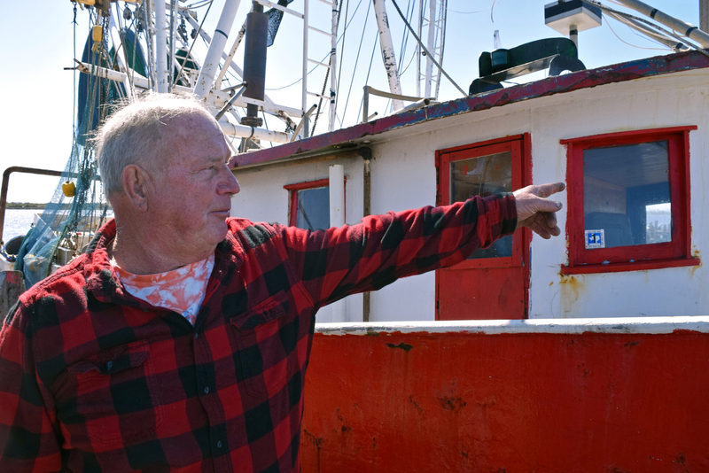 Commercial shrimper Phillip Dyson stands next to his boat, Papa’s Shadow, in Cameron.