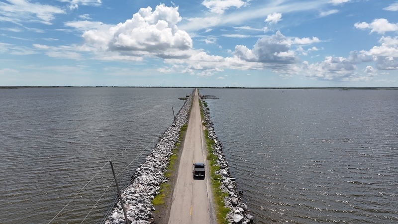 Isle de Jean Charles clings to the Louisiana coast by a narrow road flanked by rising gulf waters.