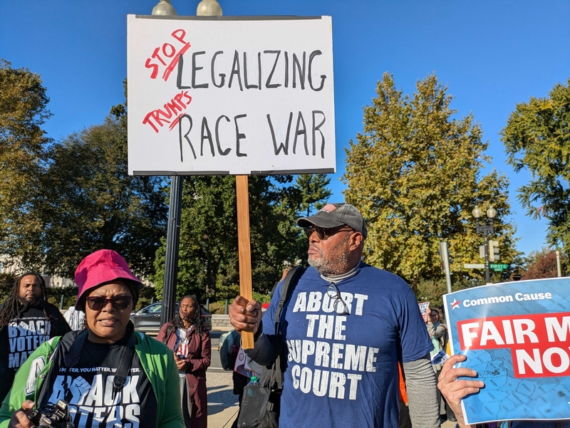 A man holds a protest sign