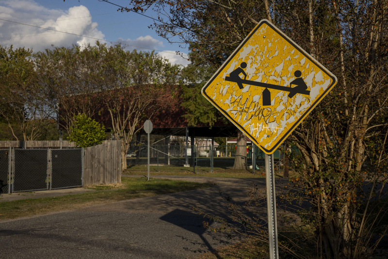 A weathered sign with an image of two children on a seesaw warns drivers children are playing nearby at Evans Playground in Uptown New Orleans