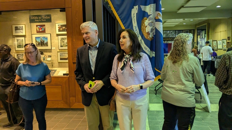 U.S. Sen. Bill Cassidy, with his wife, Dr. Laura Cassidy, speaks with reporters
