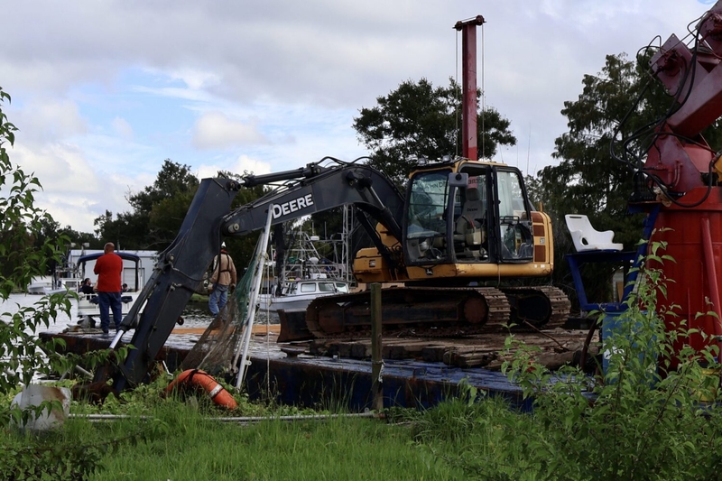 Crews remove an abandoned boat that sank in Bayou Petit Caillou.