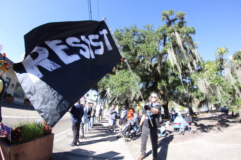 Buddy Spell of Covington waves a large flag with the word "Resist" spelled out.