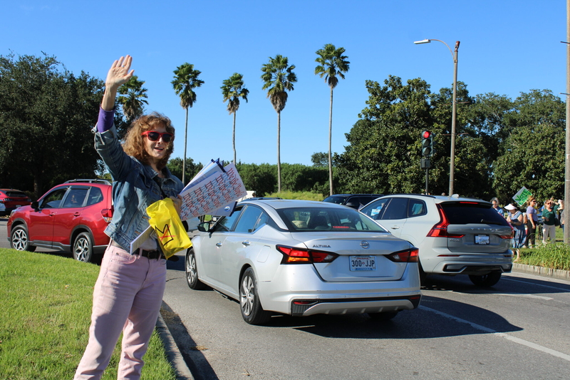 Tamara Guffey waves to motorists near the entrance of New Orleans City Park