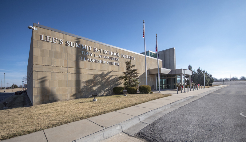 A modern office building on a clear day with the words "Lee's Summit R-VII School District" on the tile facade