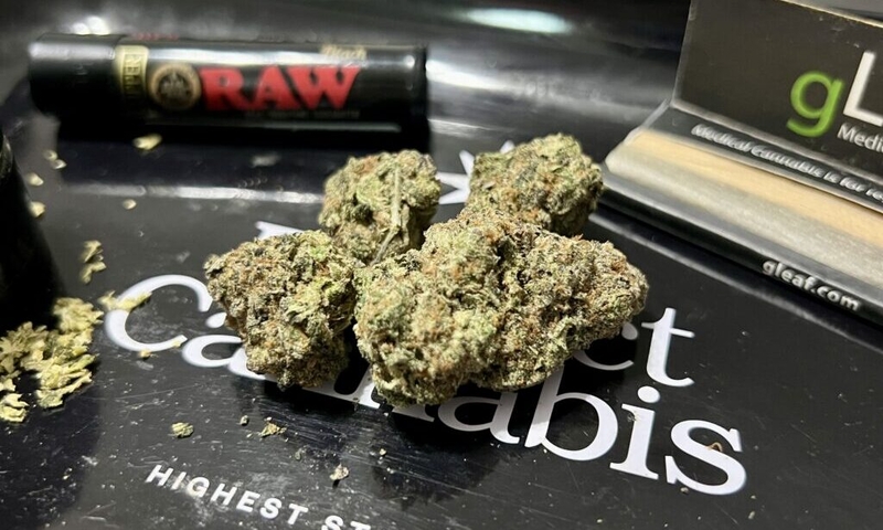 Cannabis flower rests on a rolling tray, surrounded by a pack of rolling papers, a grinder and a lighter. Lawmakers in a handful of states this year have introduced legislation to impose stricter THC limits on certain cannabis products. Photo by Amanda Watford/Stateline)