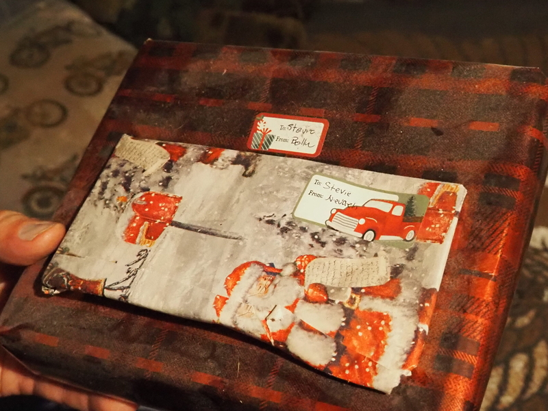 Two Christmas presents with stickers that say "To: Stevie From: Bella" and "To Stevie: From: Nevaeh" handwritten.