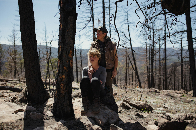 Erika Larsen and Tyler White pose for a portrait behind their property